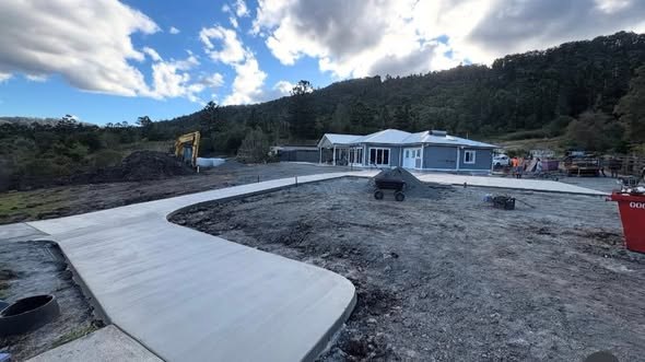 Curved concrete driveway leading to a Scenic Rim home