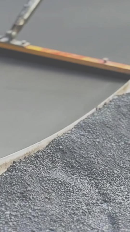 Clean cured concrete edge meeting compacted gravel