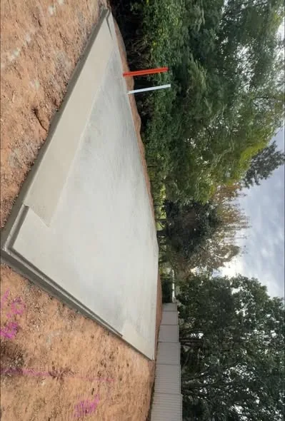 Concrete pathway running beside a hedge