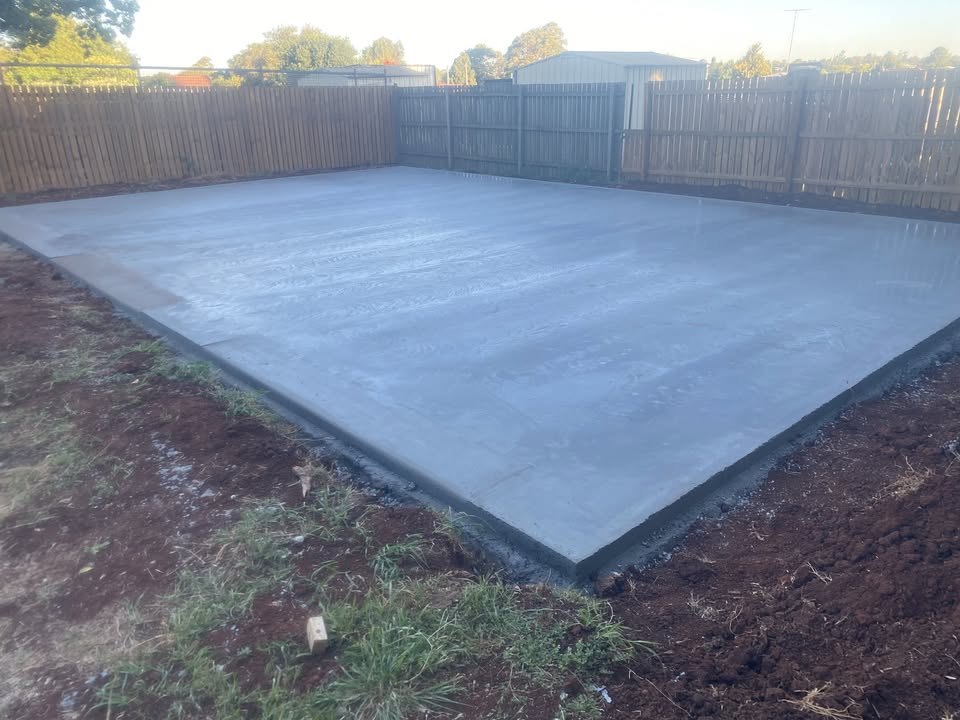 Fresh house slab poured by Woods Concreting in a fenced Toowoomba yard